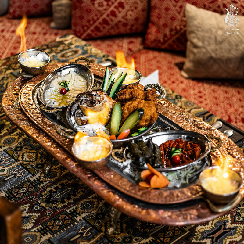 Plateau de mezzés et falafels en plats cuivrés sur nappe tissée chez Yamal Acham