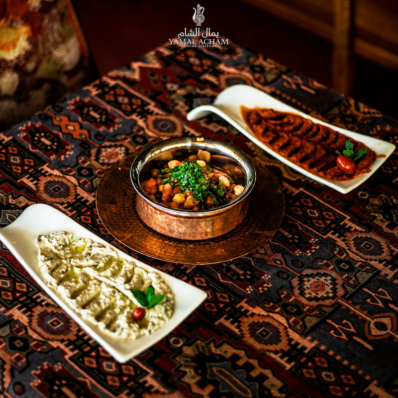 Houmous, moutabal et plat mijoté en cuivre sur tapis chez Yamal Acham