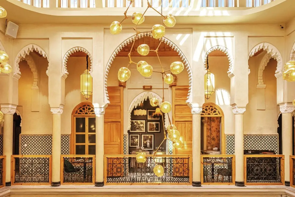 Galerie à arcades et lustres en verre ambré au-dessus du patio de Dar Dada