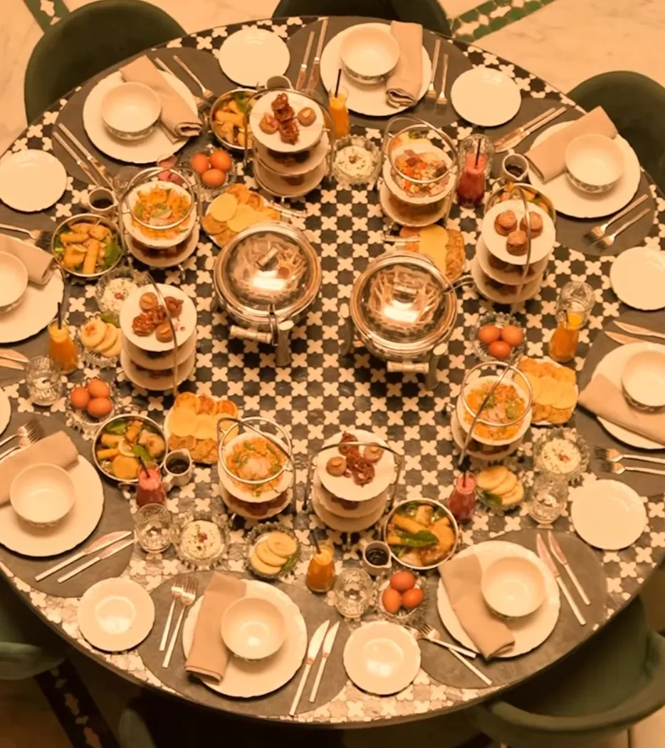 Table ronde vue du dessus chez Dar Dada, garnie de petits plats et de pâtisseries