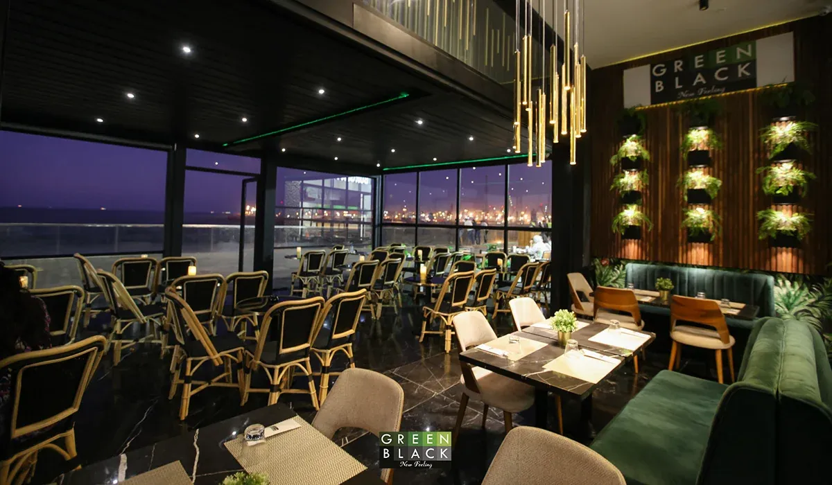 Salle de Green Black au crépuscule, baies vitrées sur la mer