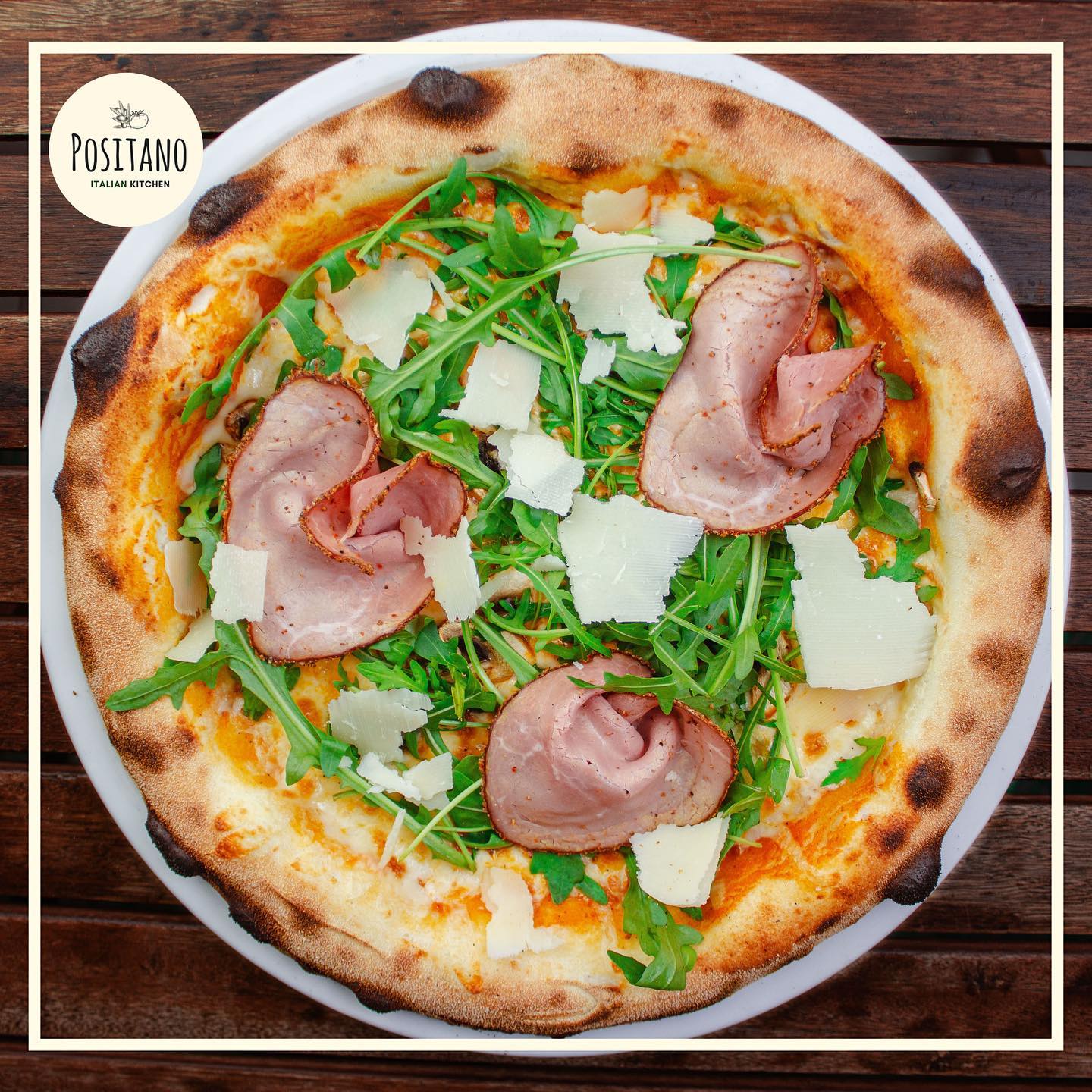 Pizza au jambon, roquette et copeaux de parmesan servie chez Positano Italian Kitchen à Fès