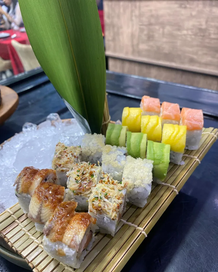 Rolls nappés de sauce et rolls croustillants sur natte de bambou chez Lbehja Sushi