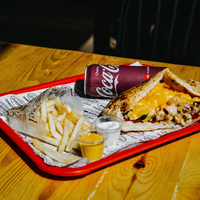 Sandwich au fromage fondu, frites et sauces sur plateau rouge chez Kakou Kebab