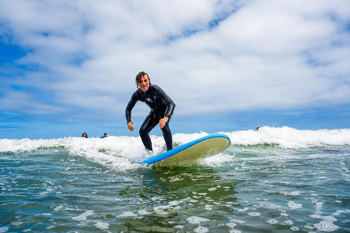 Surfeur debout sur sa planche dans la mousse, cours Casablanca Surf Coaching