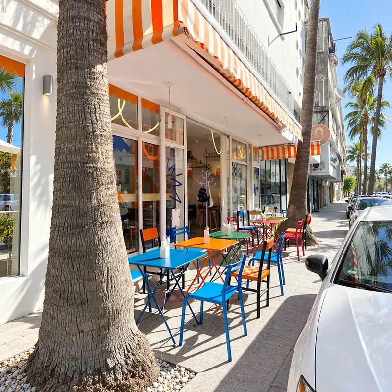 Terrasse du Boho Café rue El Yamama, chaises colorées sous un store orange et blanc