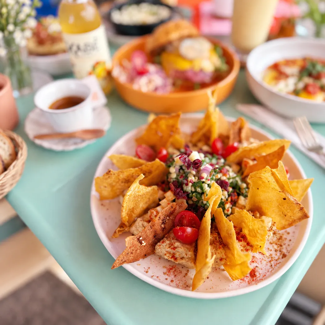Assiette salée garnie de chips et crudités au Boho Café, bols de brunch autour