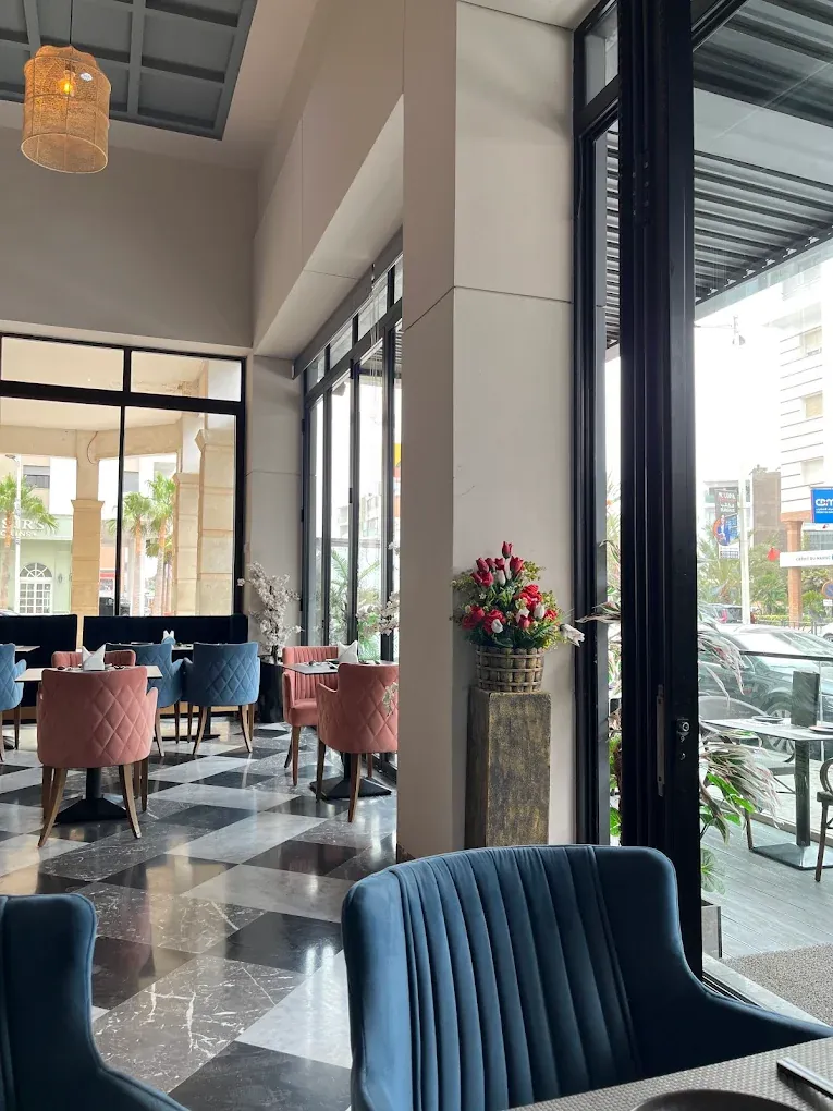 Grandes baies vitrées et fauteuils bleus et roses dans la salle de Kyoto Sushi