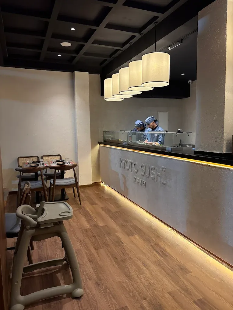 Comptoir de Kyoto Sushi à Agadir avec deux sushimen au travail derrière la vitrine réfrigérée