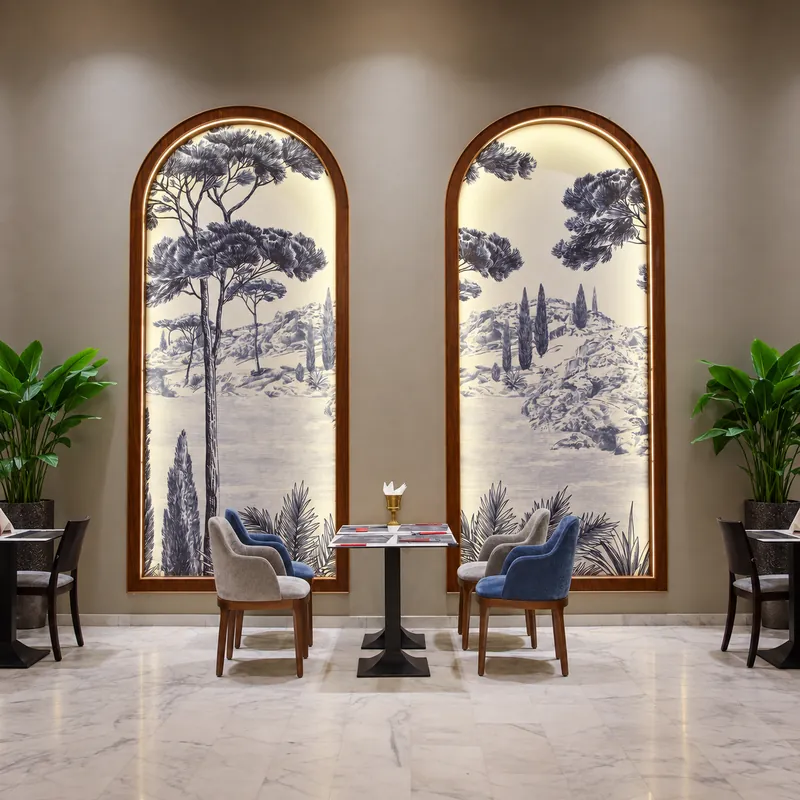 Salle de Gran Milano à Fès : sol en marbre, fauteuils bleus et arches peintes de pins parasols