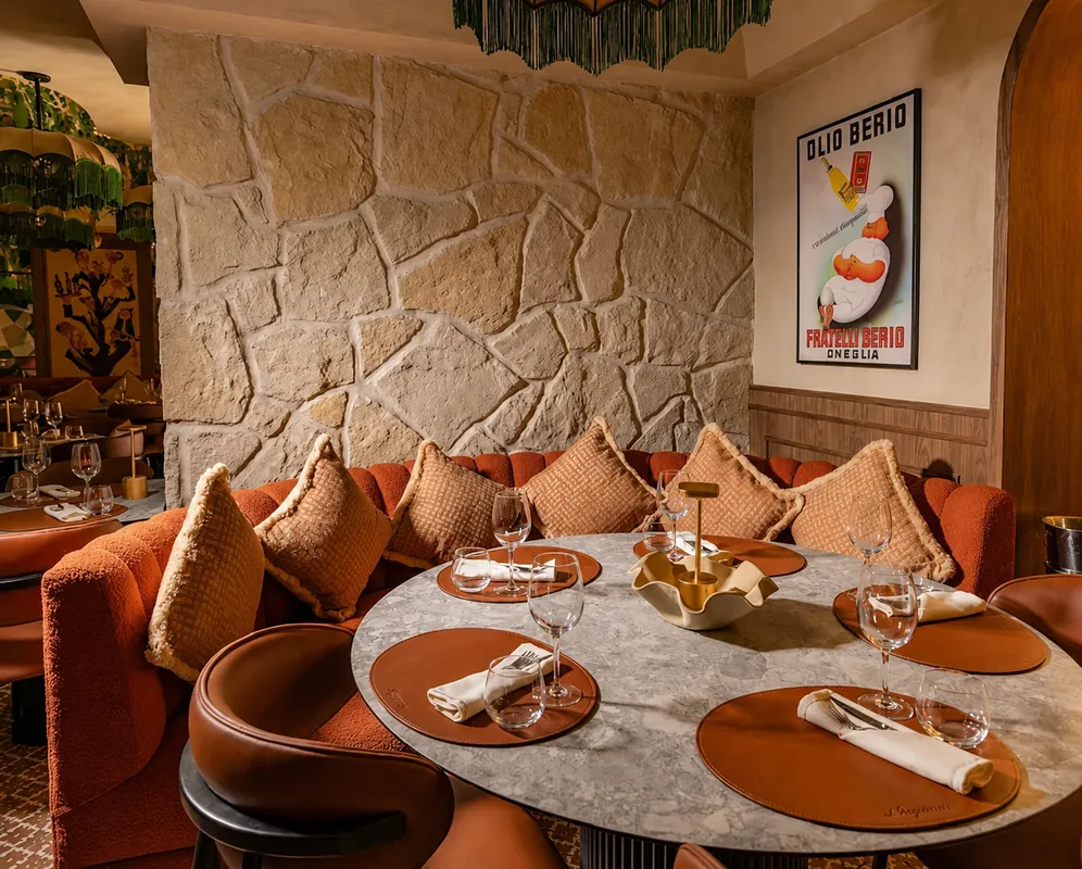 Niagara à Marrakech : table ronde dressée devant une banquette et un mur en pierre