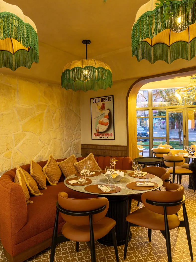 Niagara à Marrakech : salle aux murs de pierre claire, banquette terracotta et suspensions à franges vertes