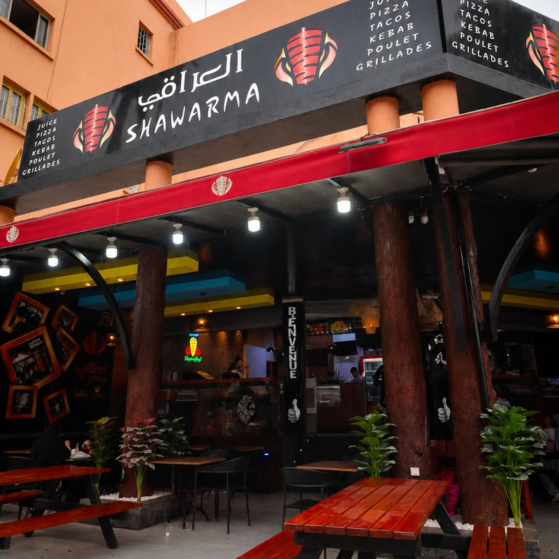 Devanture d'Iraki Shawarma à Derb Dabachi, enseigne bilingue et terrasse aux tables en bois