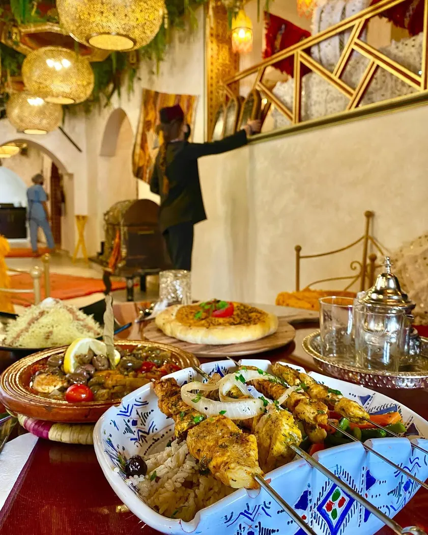 Table de Dar Naji à Rabat : brochettes sur riz, tajine aux olives, pizza marocaine et théière en argent