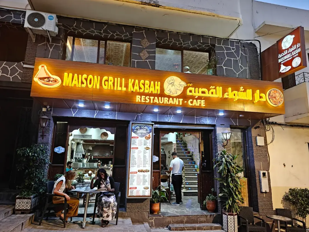 Façade éclairée de Maison Grill Kasbah, rue de la Kasbah à Tanger, avec quelques tables dehors