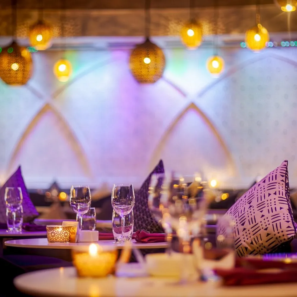 Tables dressées aux bougies et coussins à motifs au So Lounge Marrakech