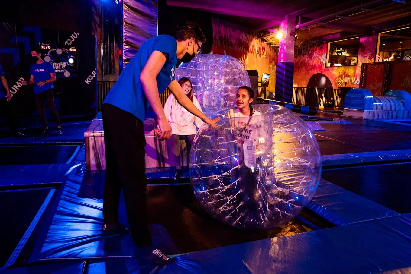 Enfants dans des bulles gonflables sur les trampolines d'un parc Kojump