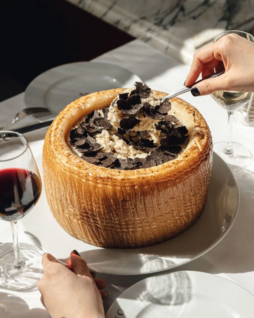 Noto à Marrakech : risotto servi dans une meule de fromage, couvert de lamelles de truffe noire