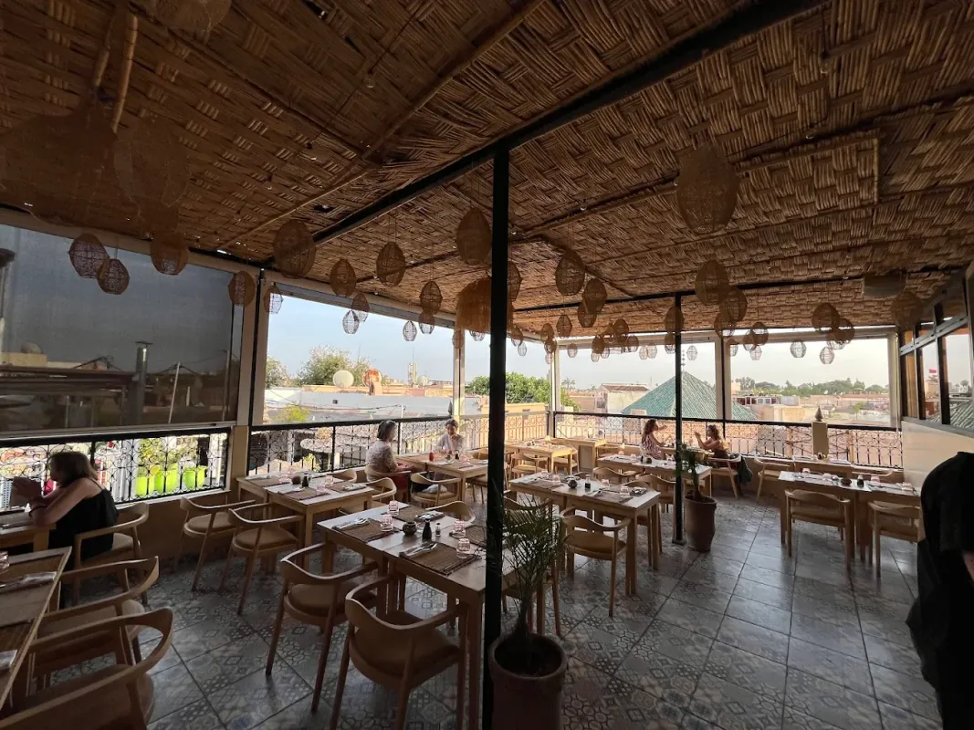 Rooftop de Wauw à Marrakech : toit en canisse, suspensions en osier et vue dégagée sur la médina