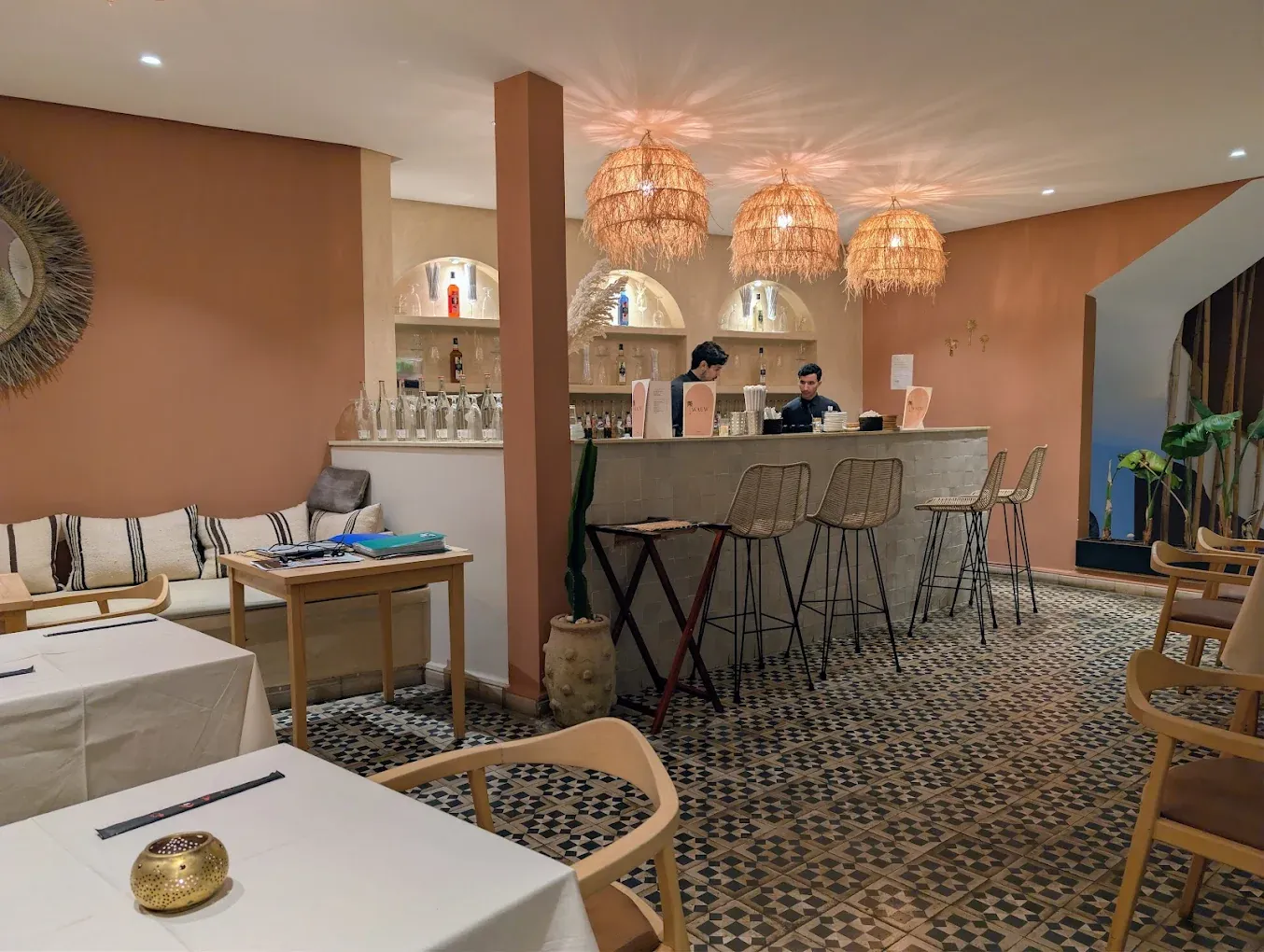 Intérieur de Wauw à Marrakech : bar clair, suspensions en raphia, sol en carreaux de ciment
