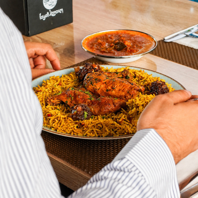 Plat de riz et poulet servi avec une sauce tomate chez Layali Karoun