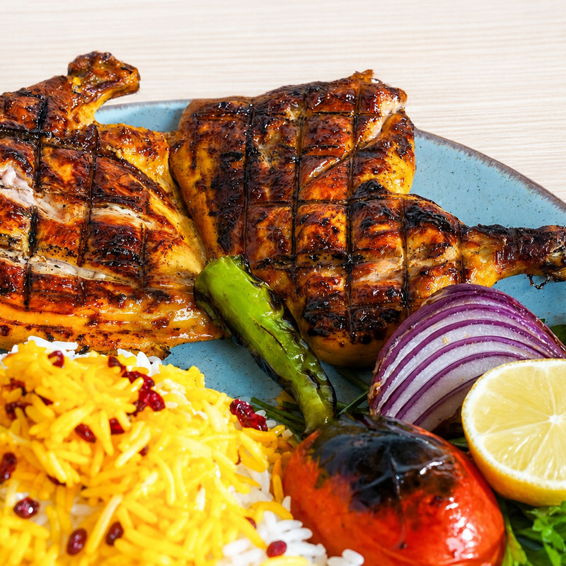 Poulet grillé, riz au safran et à l'épine-vinette, tomate et piment grillés chez Layali Karoun