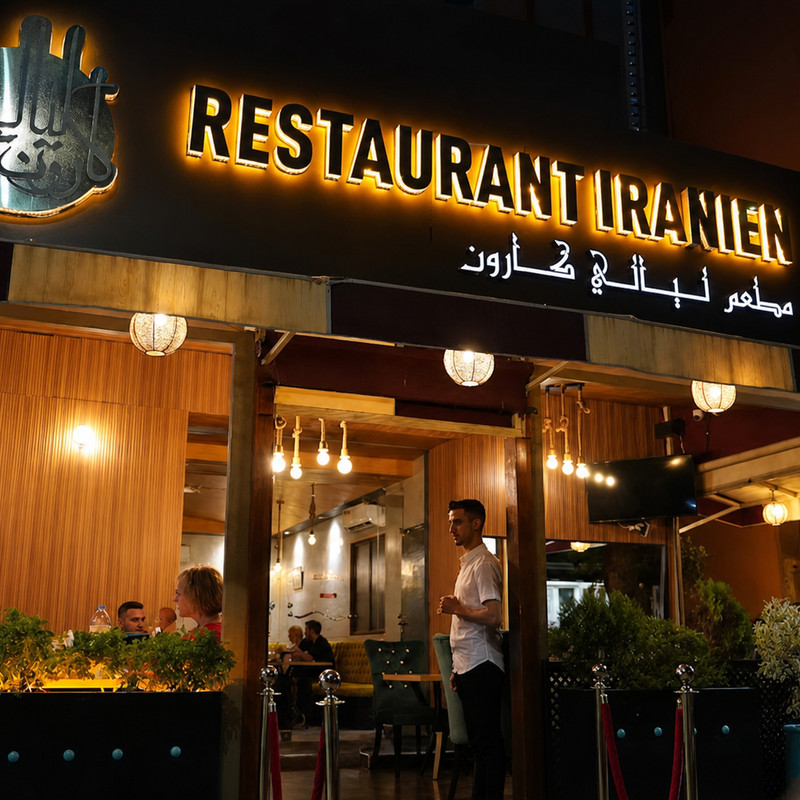 Façade éclairée du restaurant iranien Layali Karoun, avenue Mohammed V, clients en terrasse