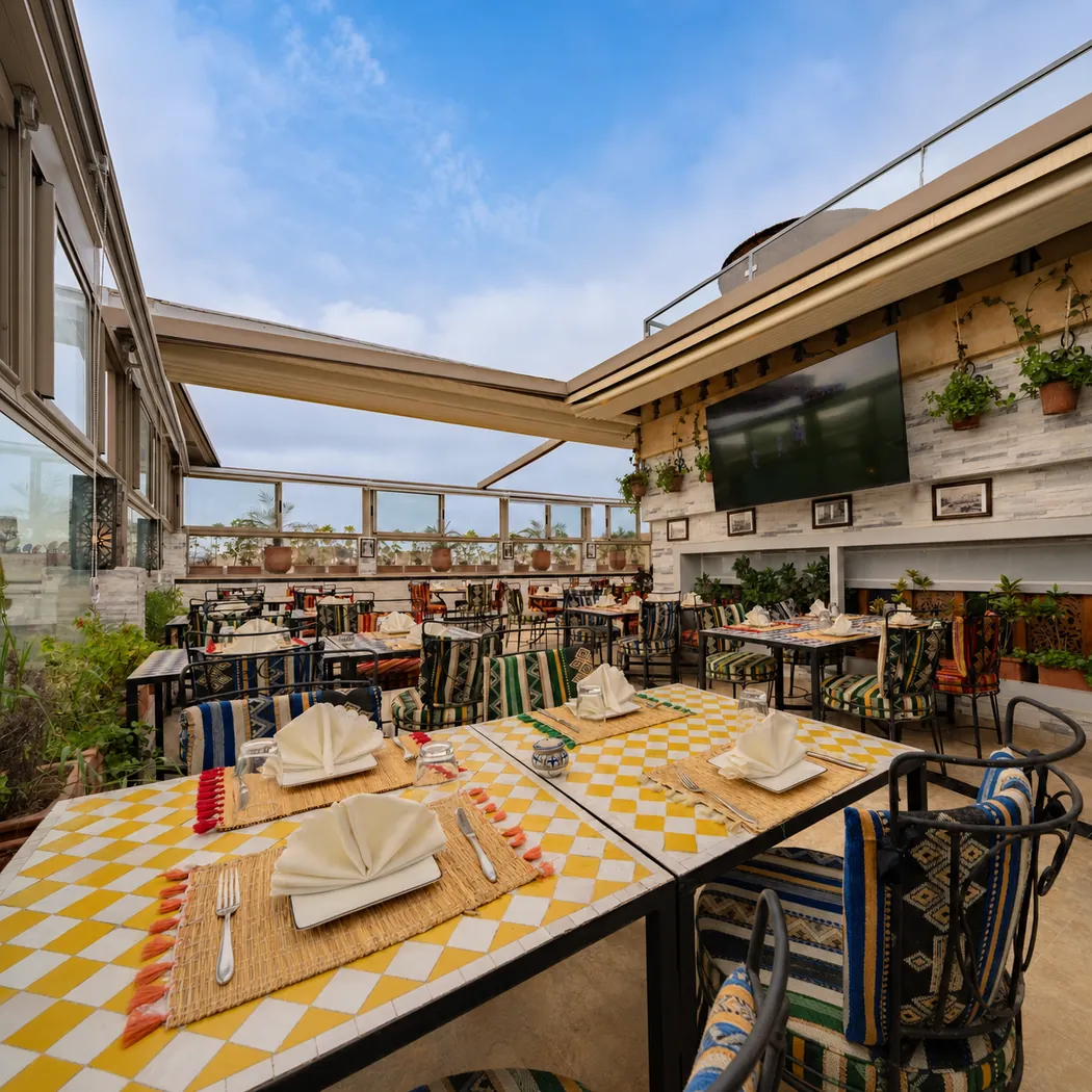 Terrasse sur le toit de Dar El Kaid, tables à nappes jaunes et vue sur la ville