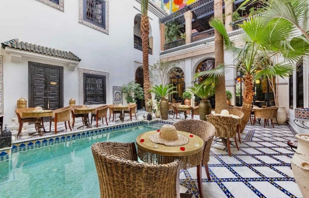 Patio du Riad Monceau avec bassin, zellige et fauteuils en osier