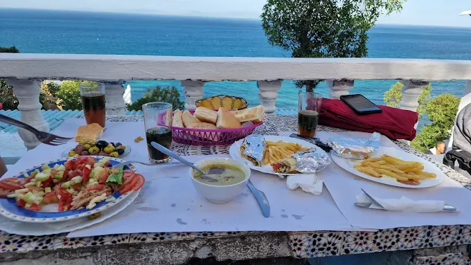 Table du Café Hafa avec salade, soupe et frites, balustrade et mer en fond