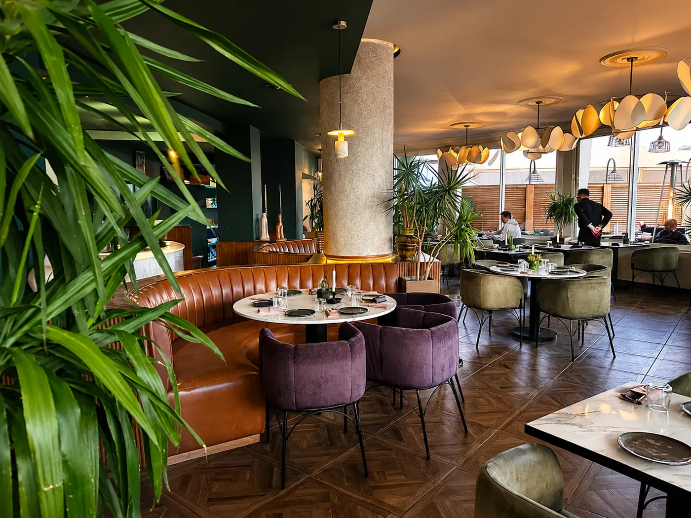 Salle du Restaurant Jade : banquette en cuir, fauteuils velours et suspensions en forme de fleurs