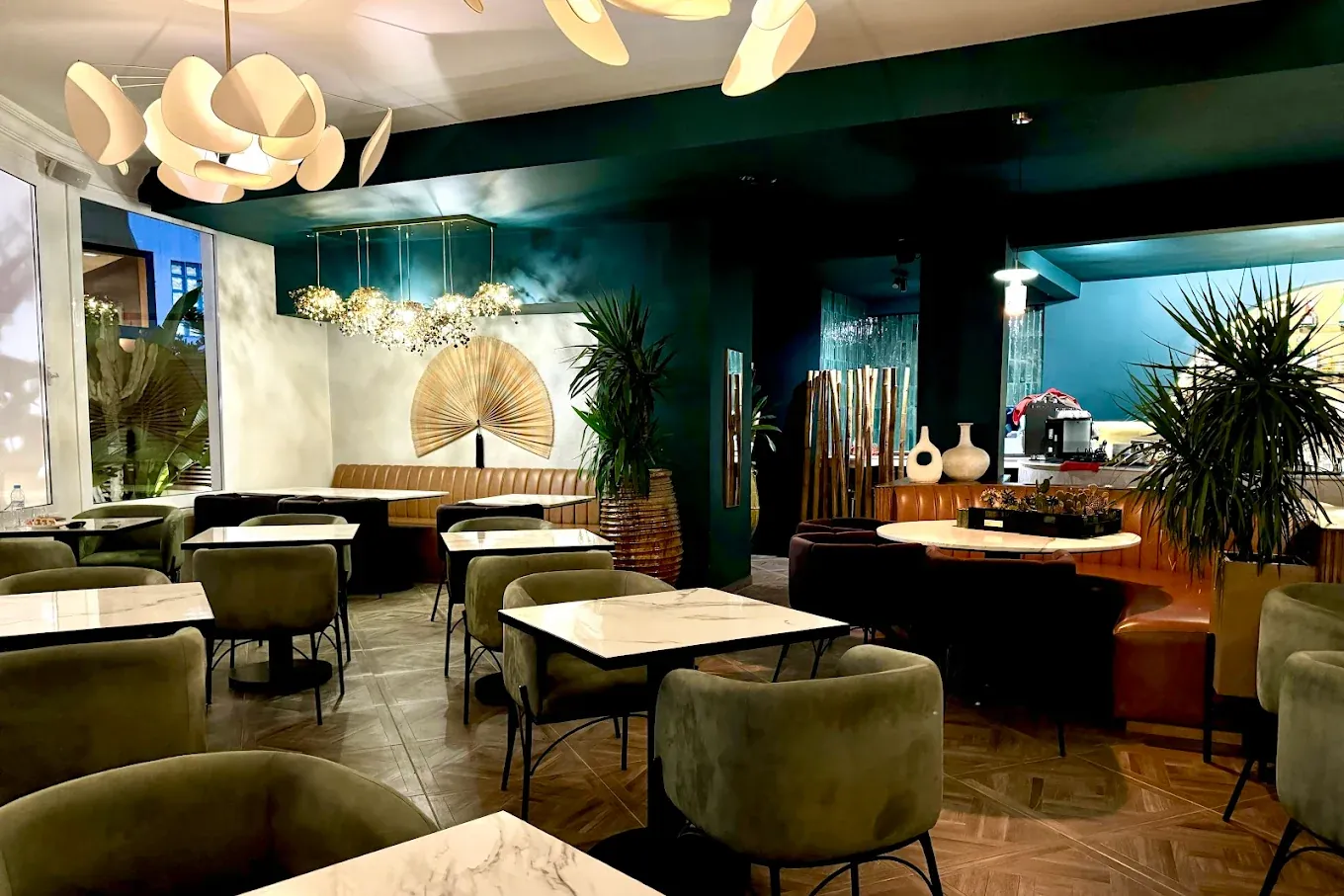 Salle aux murs vert profond du Restaurant Jade, fauteuils olive et éventail décoratif