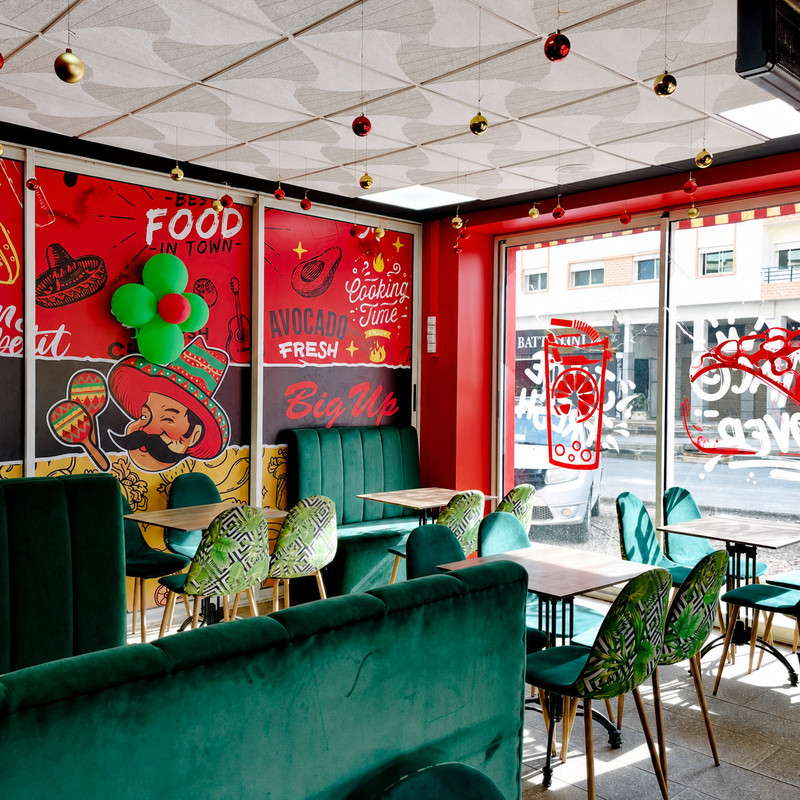 Salle de Tacos Big Up à Casablanca, banquettes vertes et fresques rouges au mur