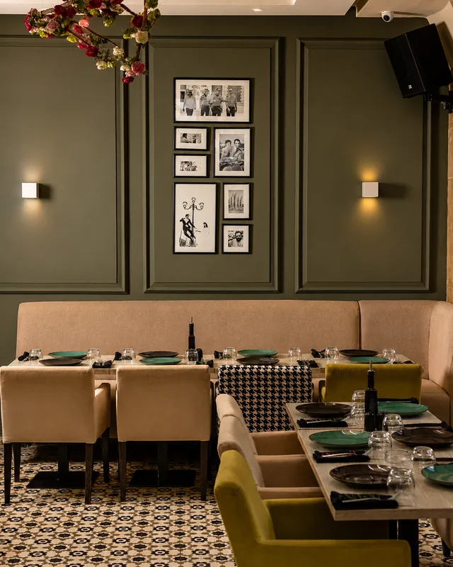 Finzi à Rabat : salle aux murs vert olive, banquette beige et photos en noir et blanc encadrées