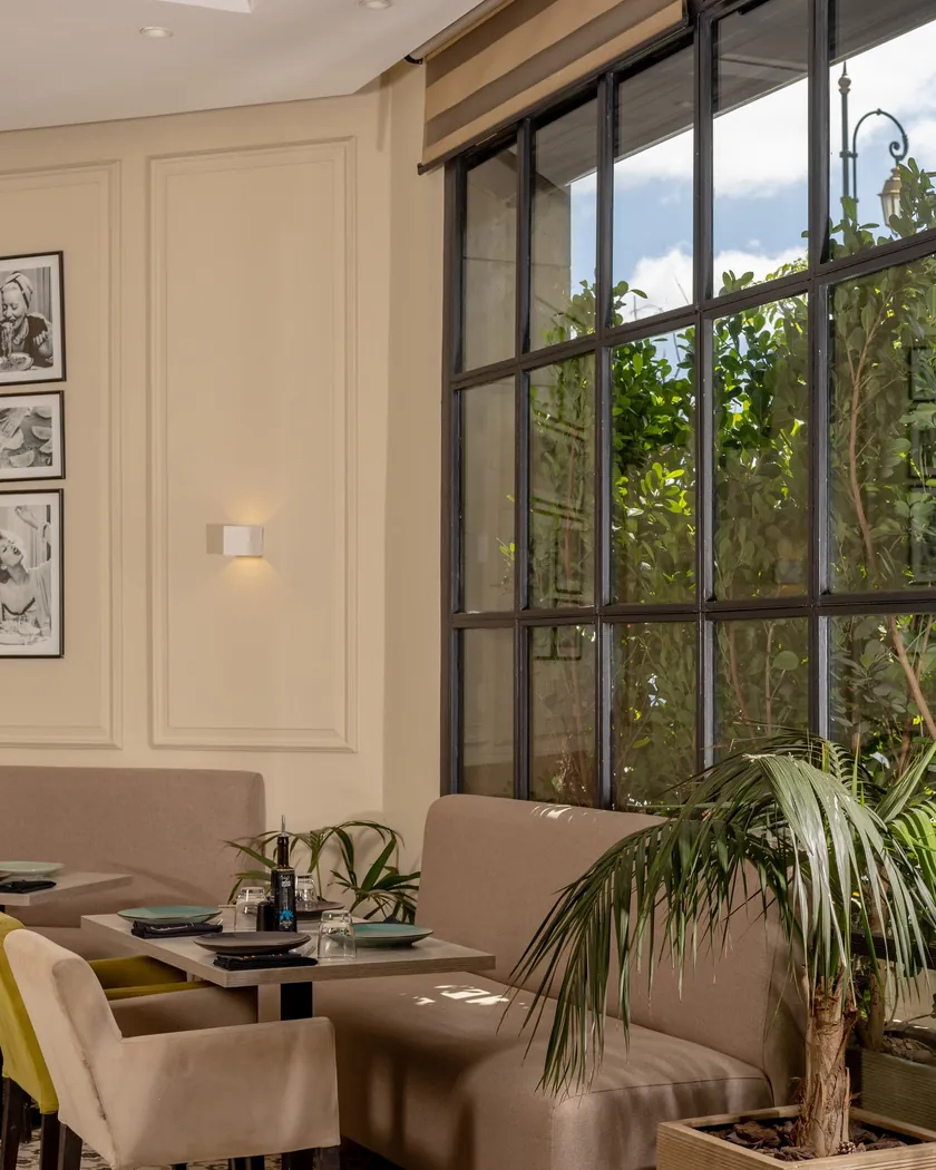 Finzi à Rabat : coin de salle clair près d'une verrière, banquettes et plantes vertes