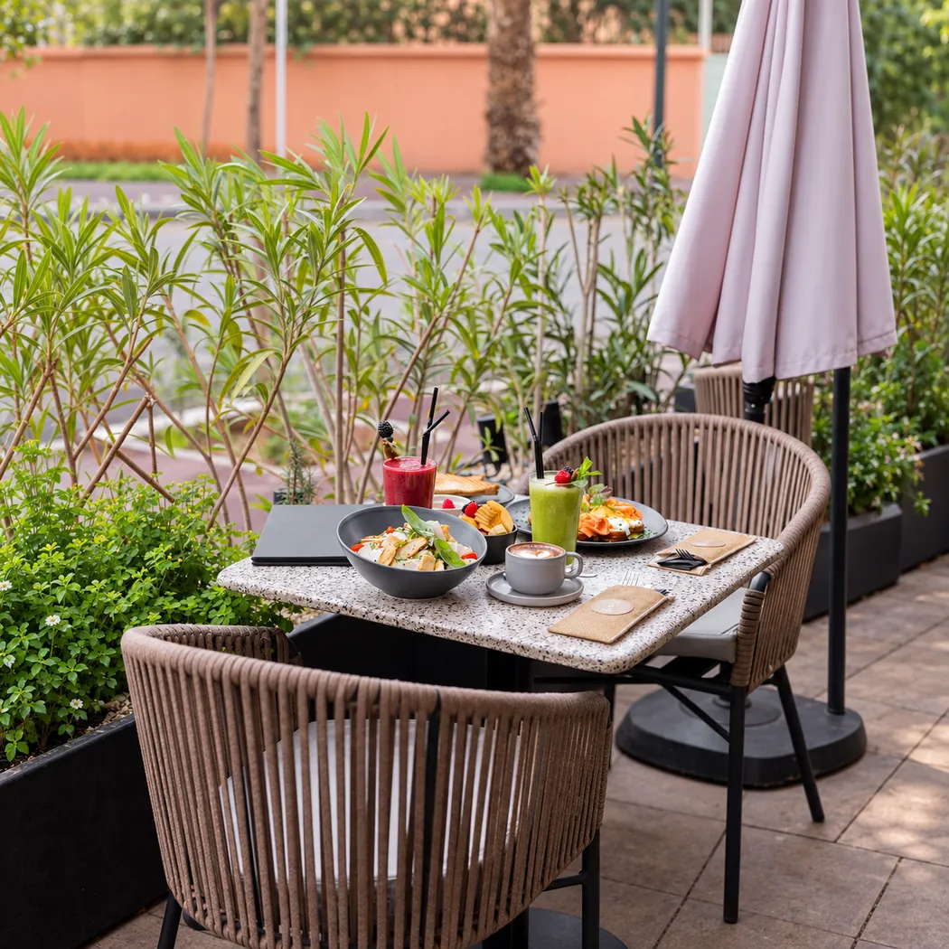 Terrasse végétalisée de Lili & Oli avec fauteuils tressés et parasol