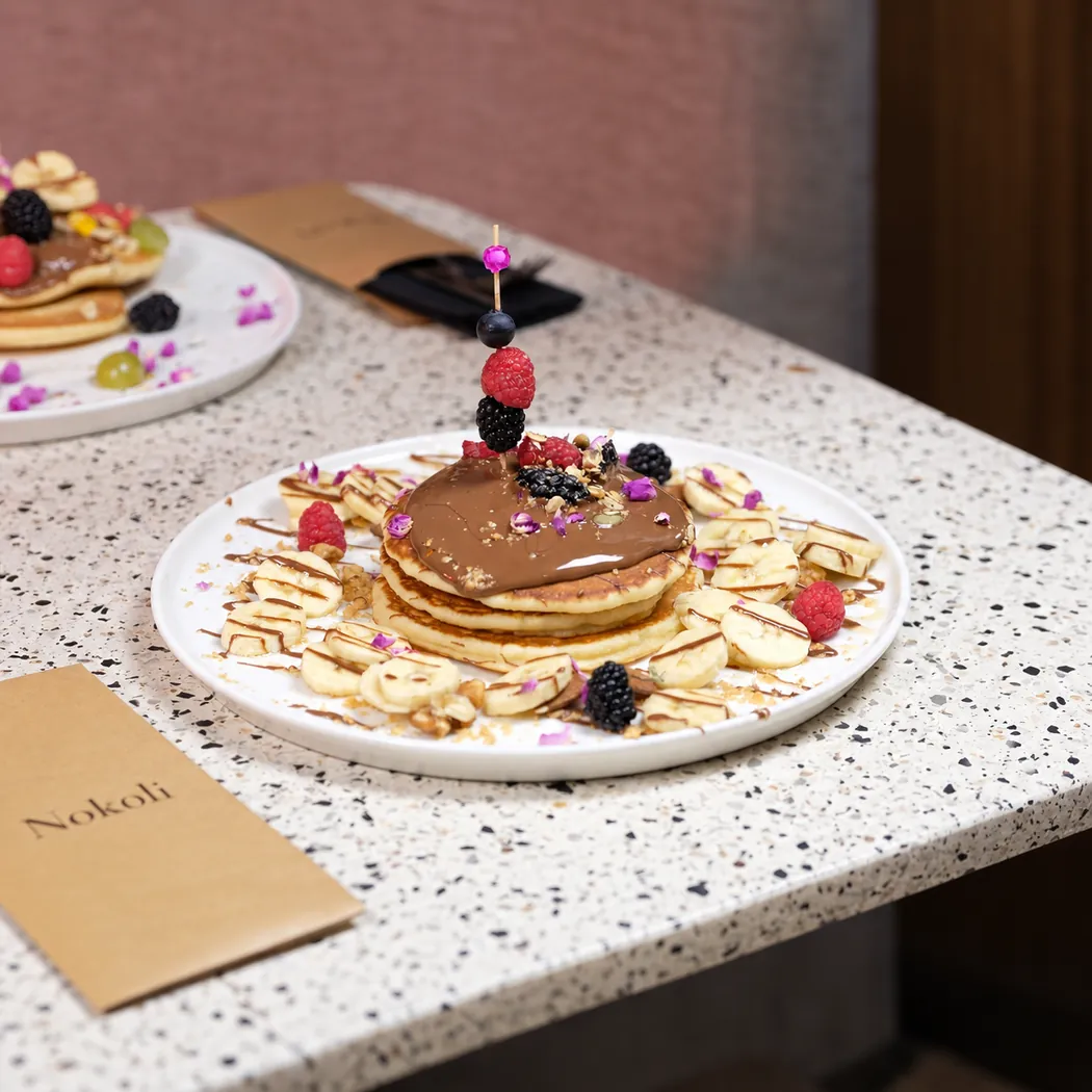 Pancakes nappés de chocolat, banane et fruits rouges chez Lili & Oli