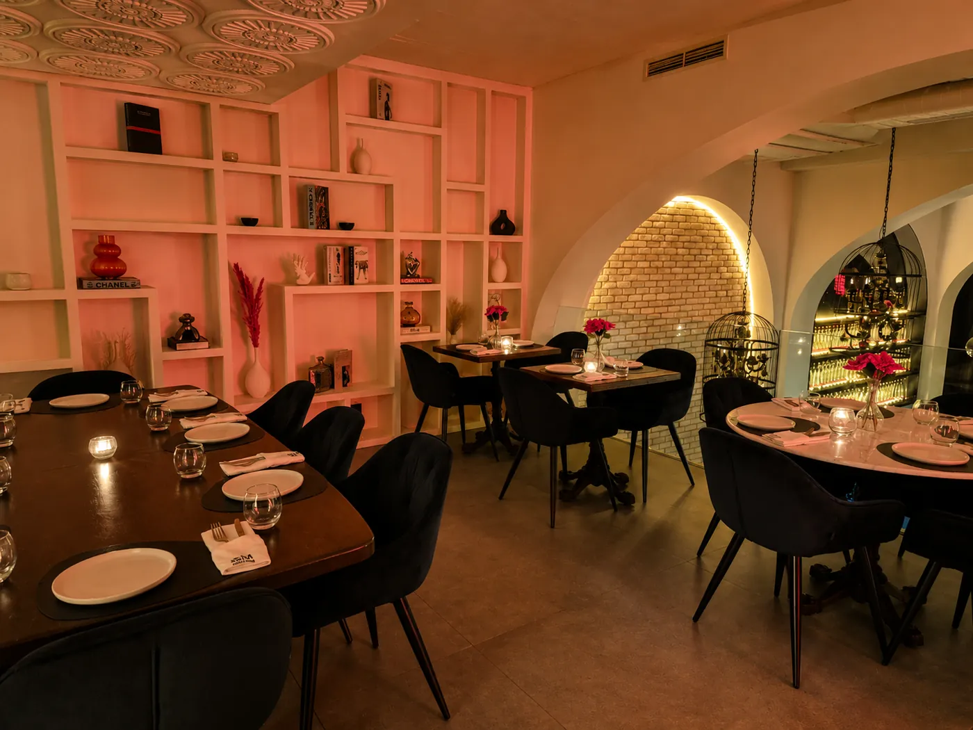 Da Milena à Rabat : salle aux étagères éclairées en rose, tables dressées et bougies