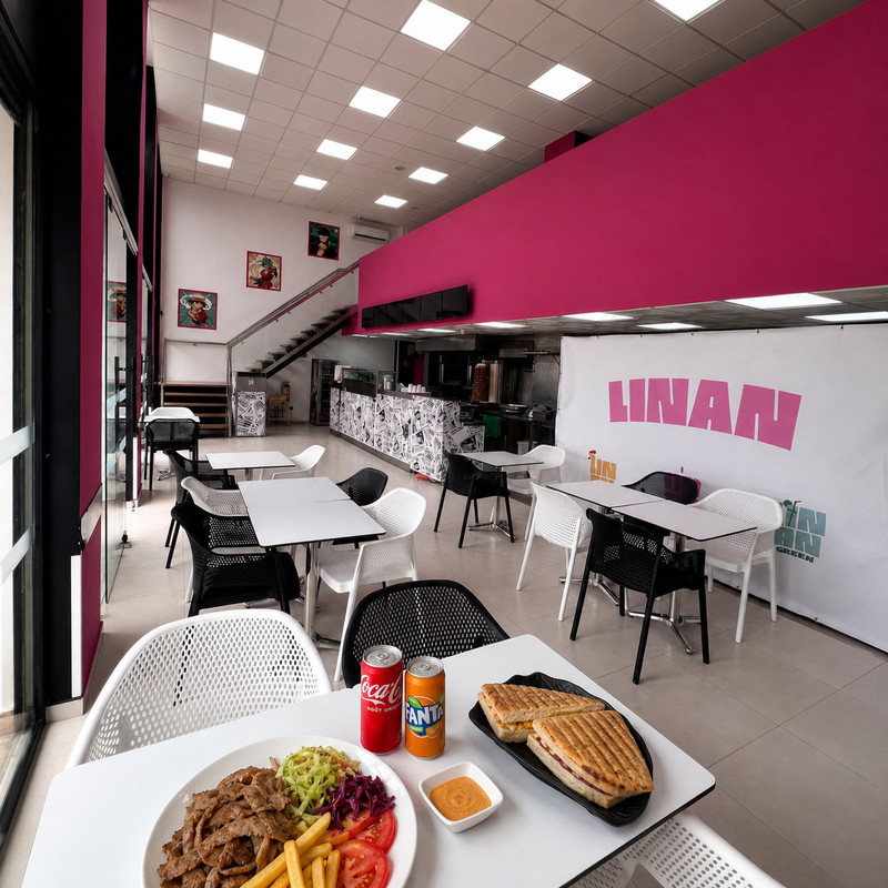 Salle de Linan Kebab aux murs roses et blancs, tables blanches et mezzanine